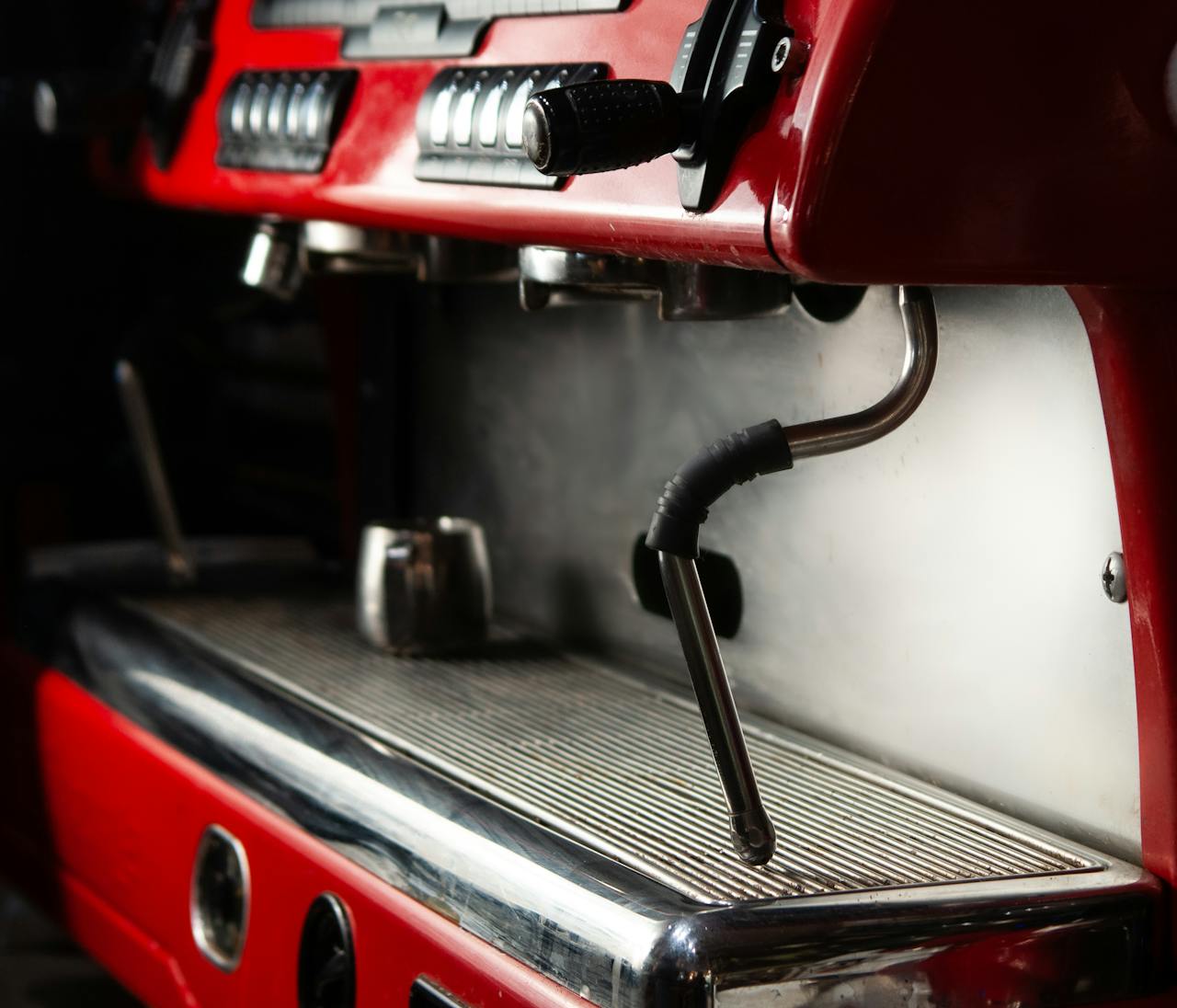 Detailed view of a red espresso machine in a café, highlighting its machinery.